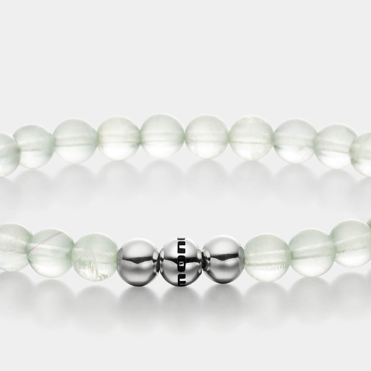 Gesamtansicht eines hellgrünen Perlenarmbandes aus echten Fluoritperlen mit drei antiallergenen Edelstahlperlen.