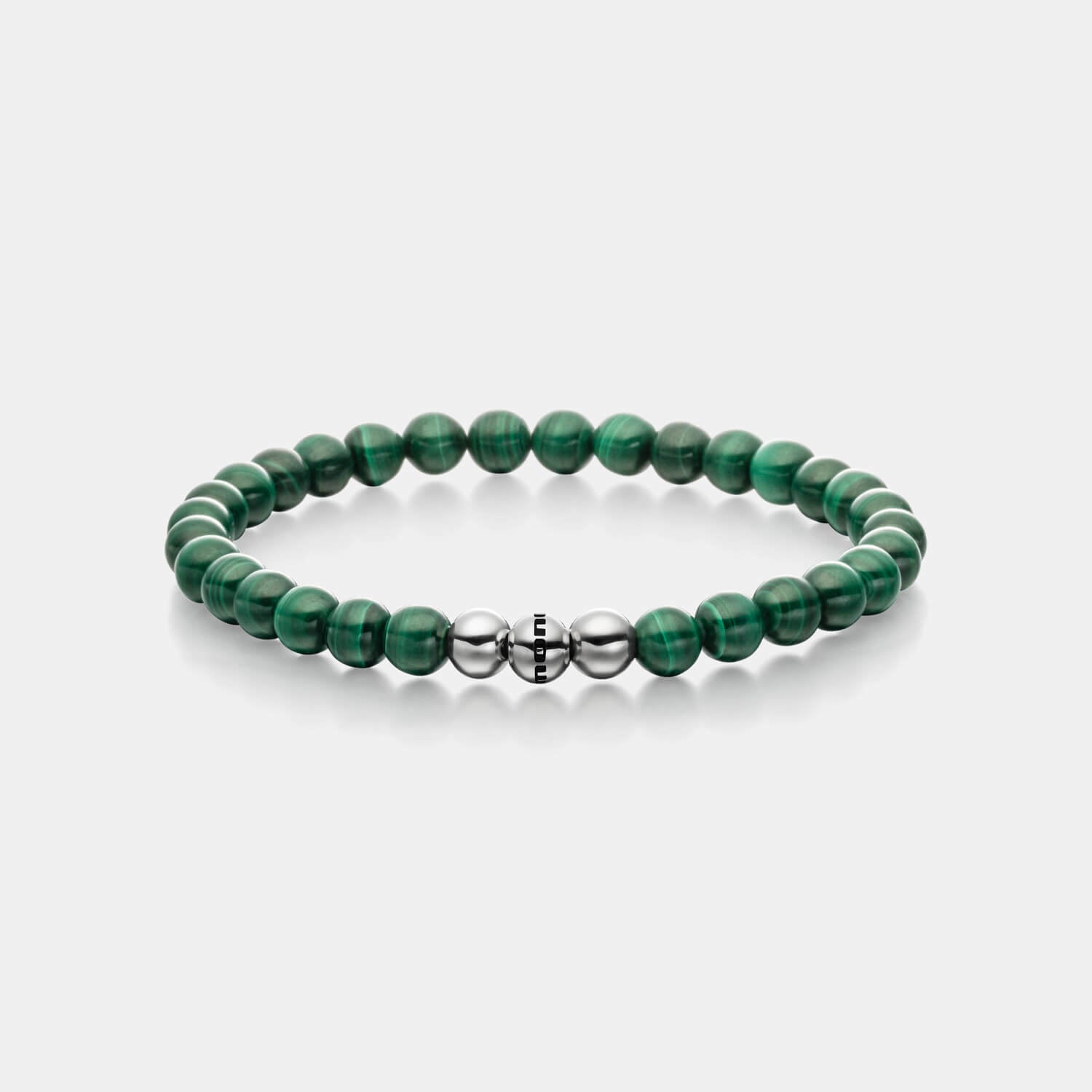 Gesamtansicht eines Perlenarmbandes aus echten grünen Malachitperlen mit drei antiallergenen Edelstahlperlen.