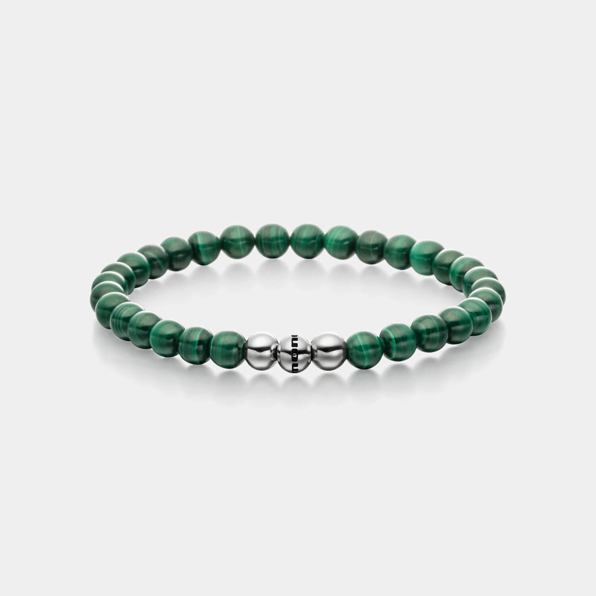Gesamtansicht eines Perlenarmbandes aus echten grünen Malachitperlen mit drei antiallergenen Edelstahlperlen.