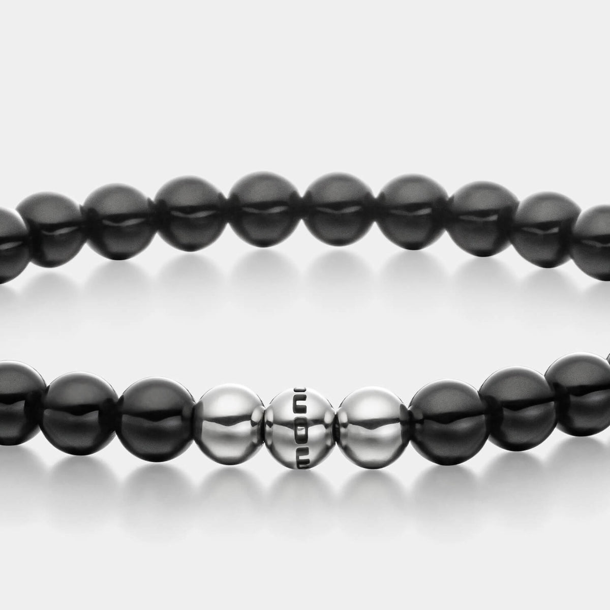 Gesamtansicht eines schwarzen Perlenarmbandes aus echten Onyxperlen mit drei antiallergenen Edelstahlperlen.