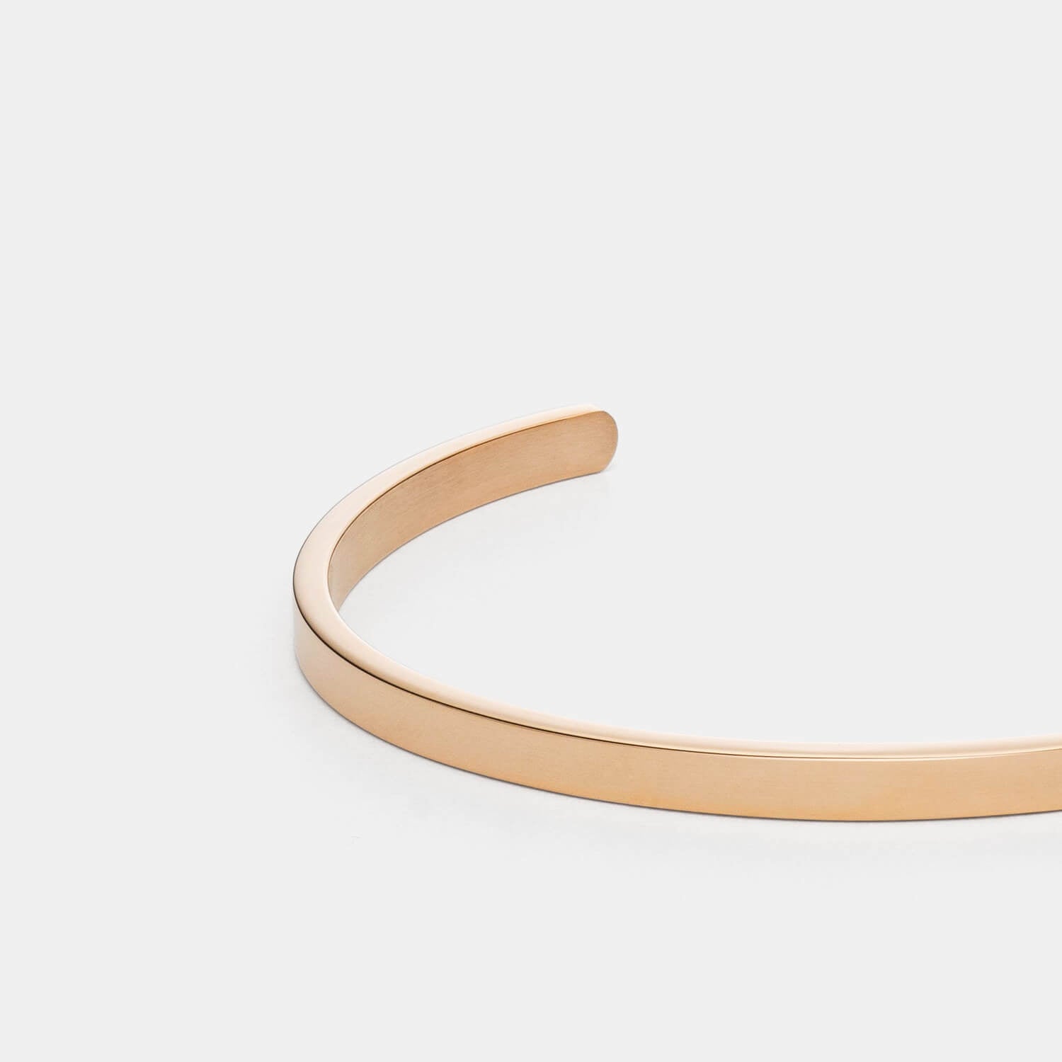 Gesamtansicht des eleganten, sehr schmalen Armreifs aus gebürstetem, antiallergenem Edelstahl in der Farbe Roségold von MONOMANIA.