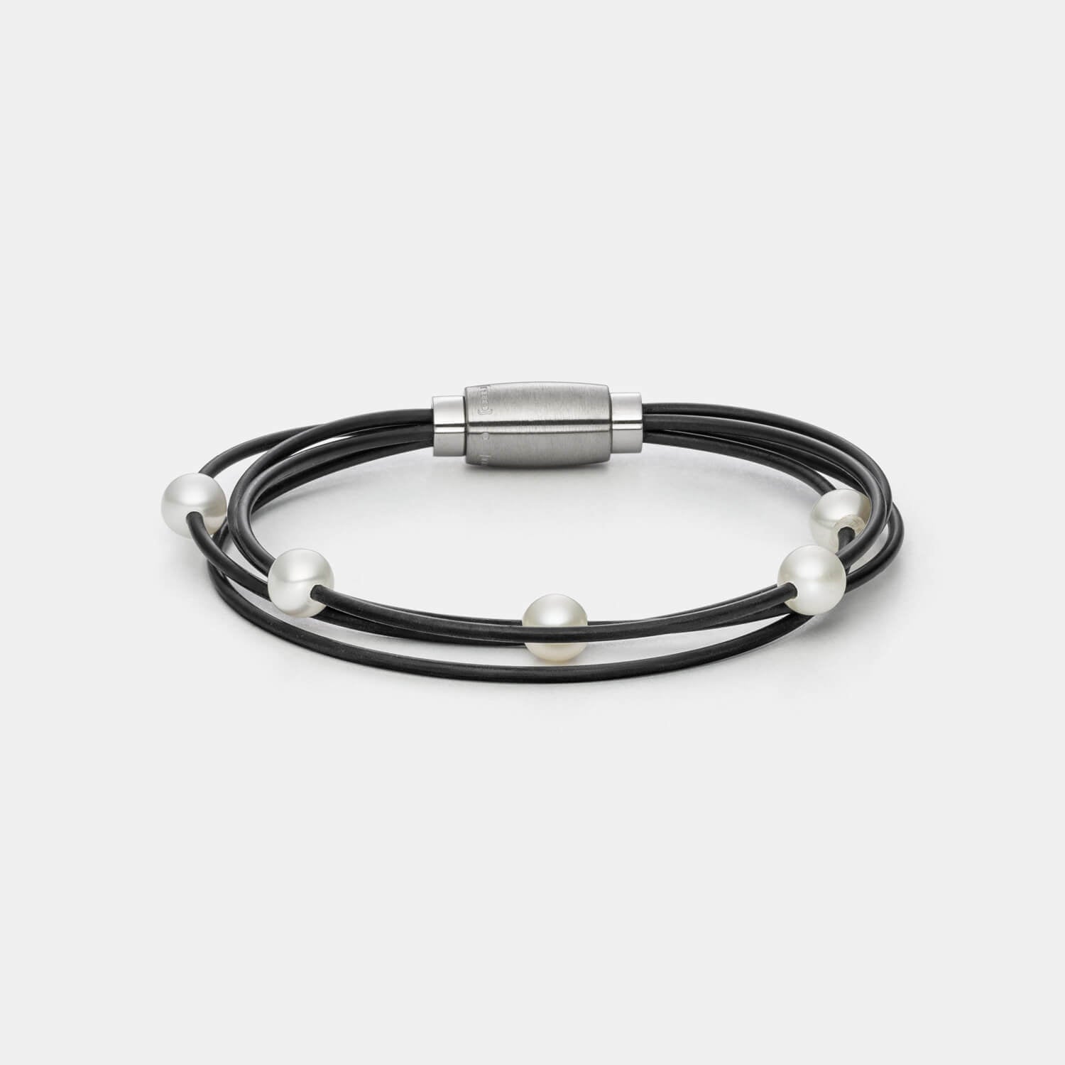 Gesamtansicht des modernen Armbandes mit echten, weißen Süßwasserperlen auf einem vierreihigen Kautschukband von MONOMANIA.