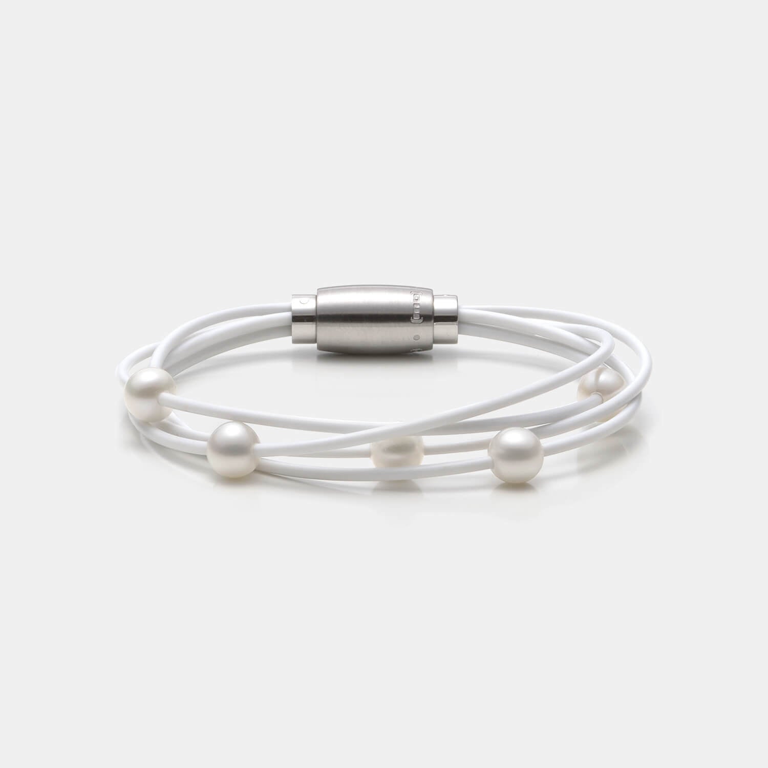 Gesamtansicht des edlen Armbandes mit echten, weißen Süßwasserperlen auf einem vierreihigen, weißen Kautschukband von MONOMANIA.