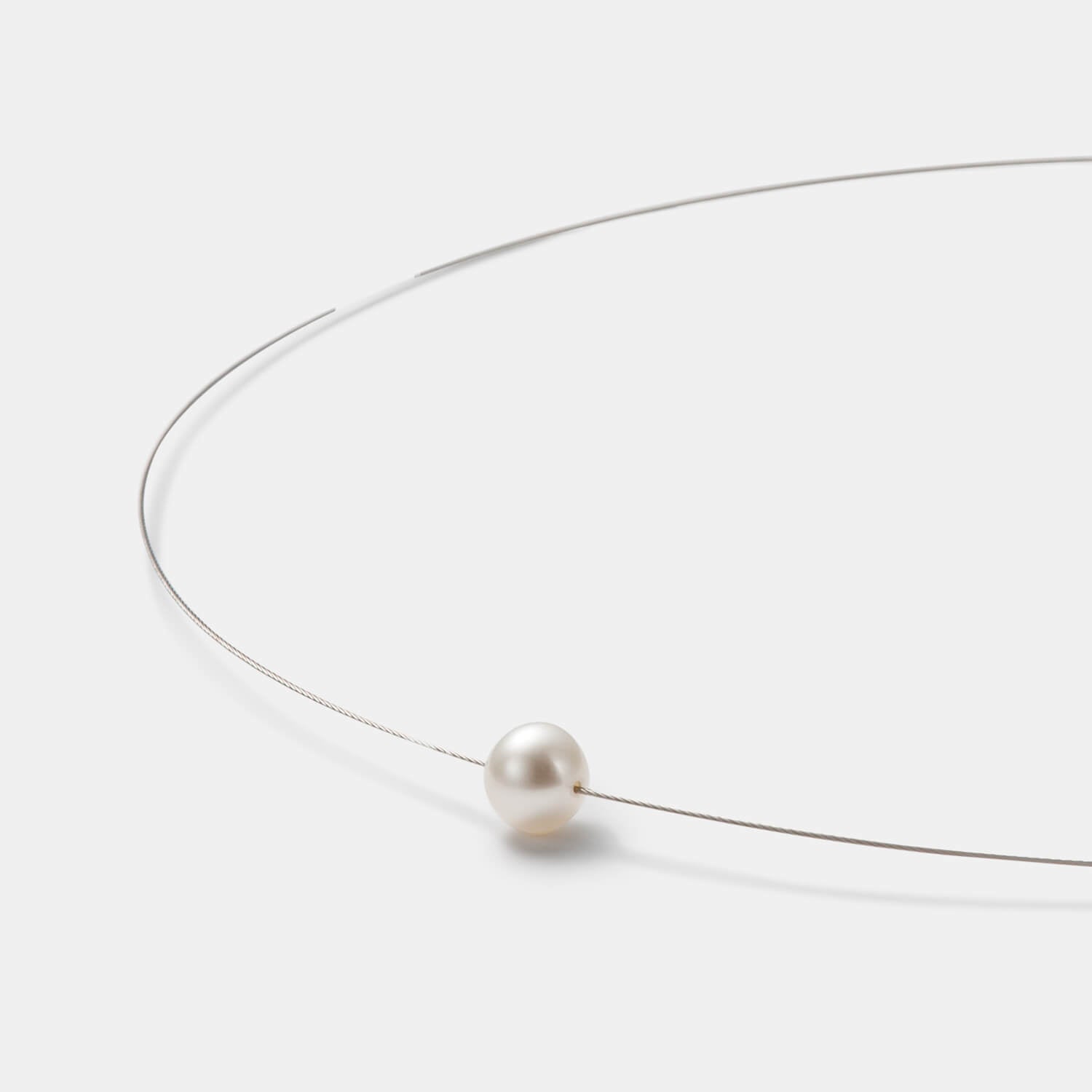 Detailansicht des edlen Colliers aus antiallergenem Edelstahl mit kleiner, weißer Süßwasserperle von MONOMANIA.