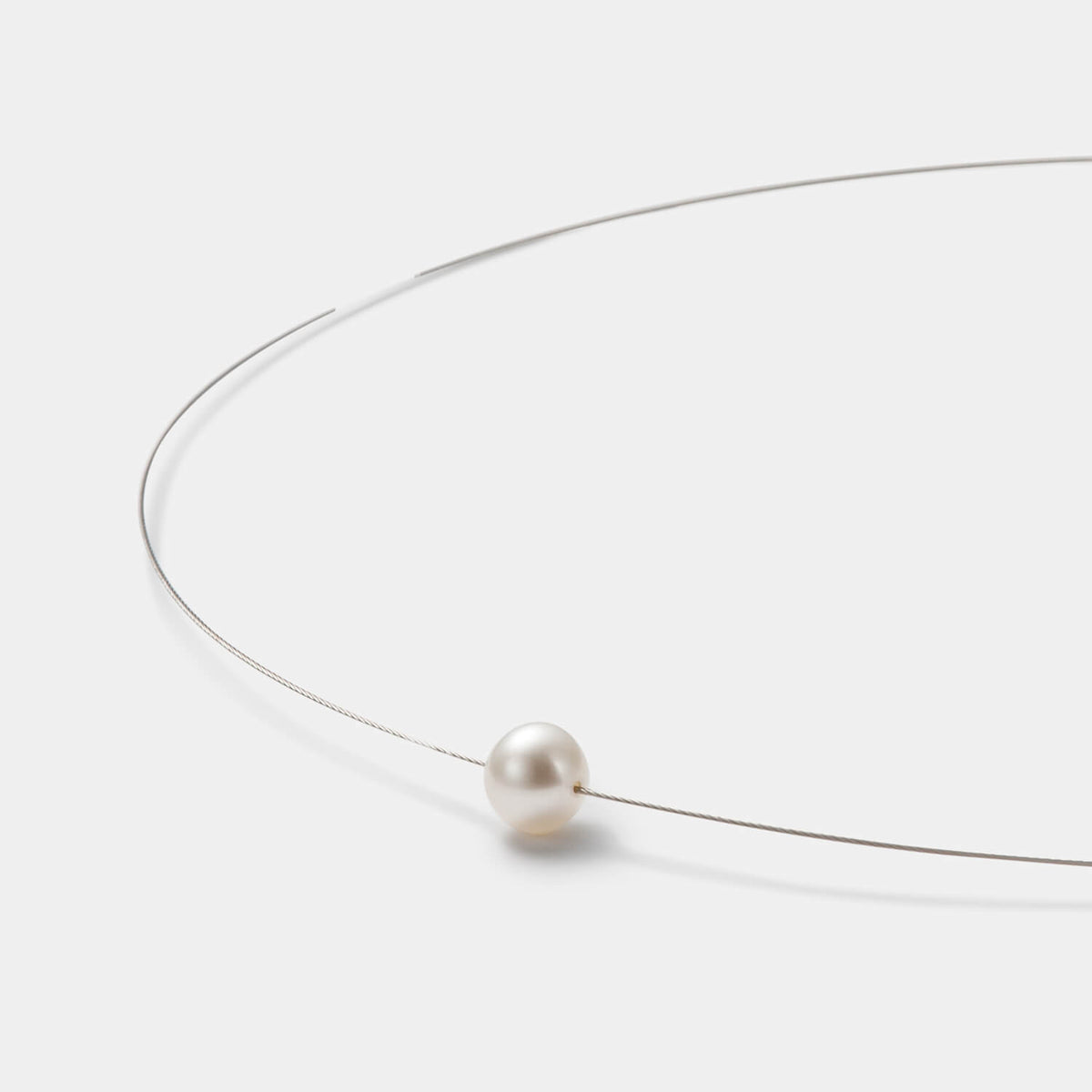 Detailansicht des edlen Colliers aus antiallergenem Edelstahl mit kleiner, weißer Süßwasserperle von MONOMANIA.