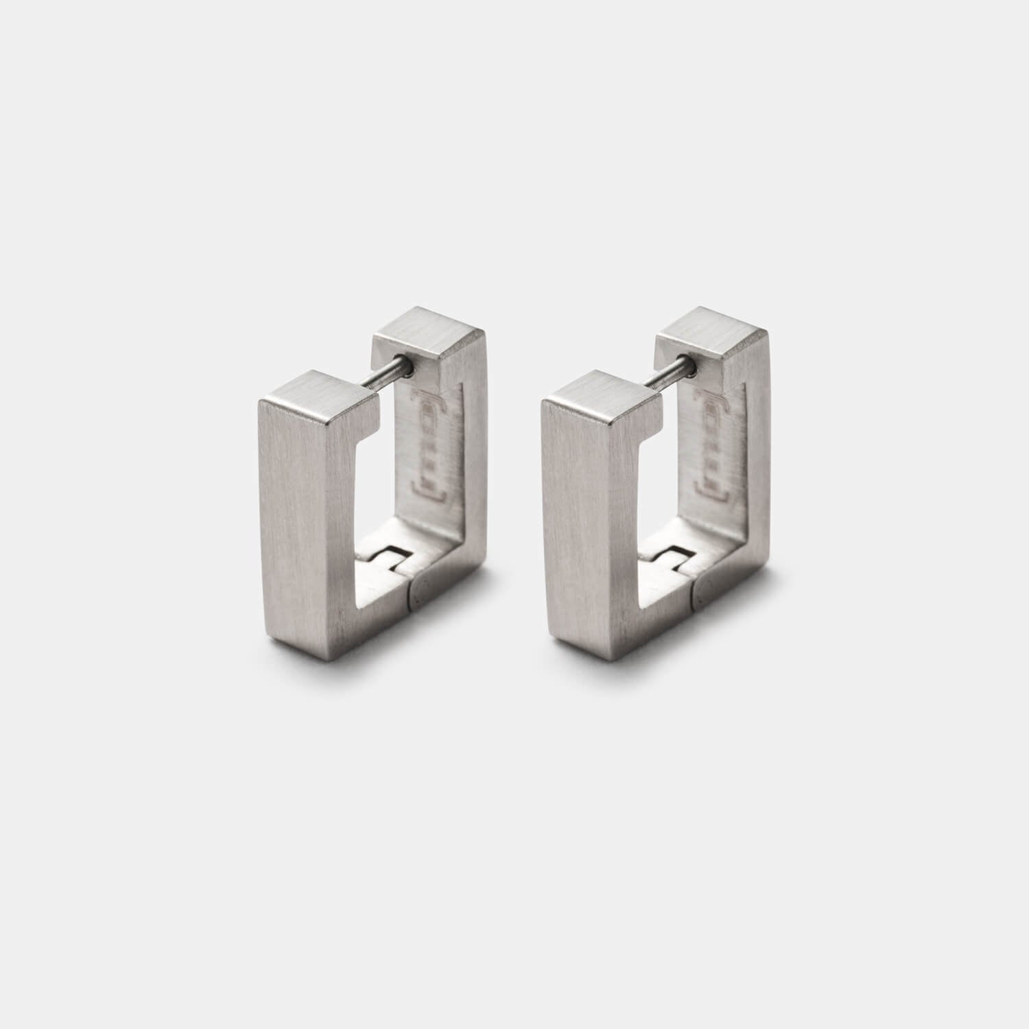 Perspektivische Gesamtansicht quadratischer Klappcreolen aus gebürstetem, antiallergenem Edelstahl von MONOMANIA.