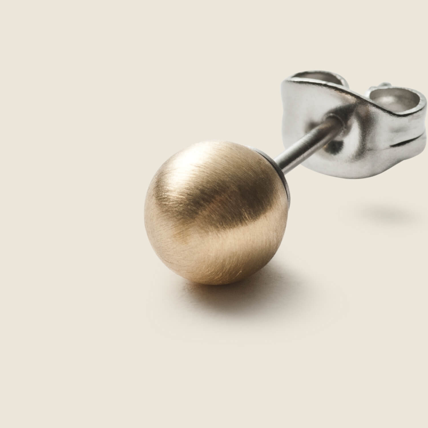 Gesamtansicht zweier Edelstahl-Ohrsteckern mit Echtgoldperle von MONOMANIA.