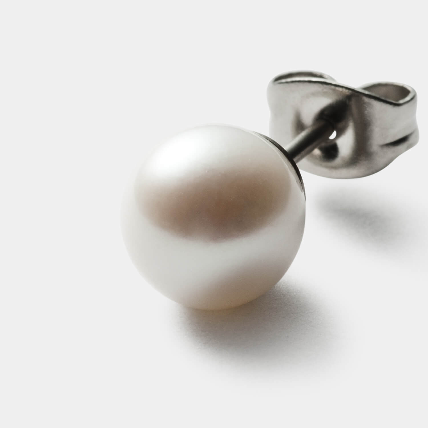 Gesamtansicht von zwei Ohrsteckern mit großen, weißen Süßwasserperlen von MONOMANIA.