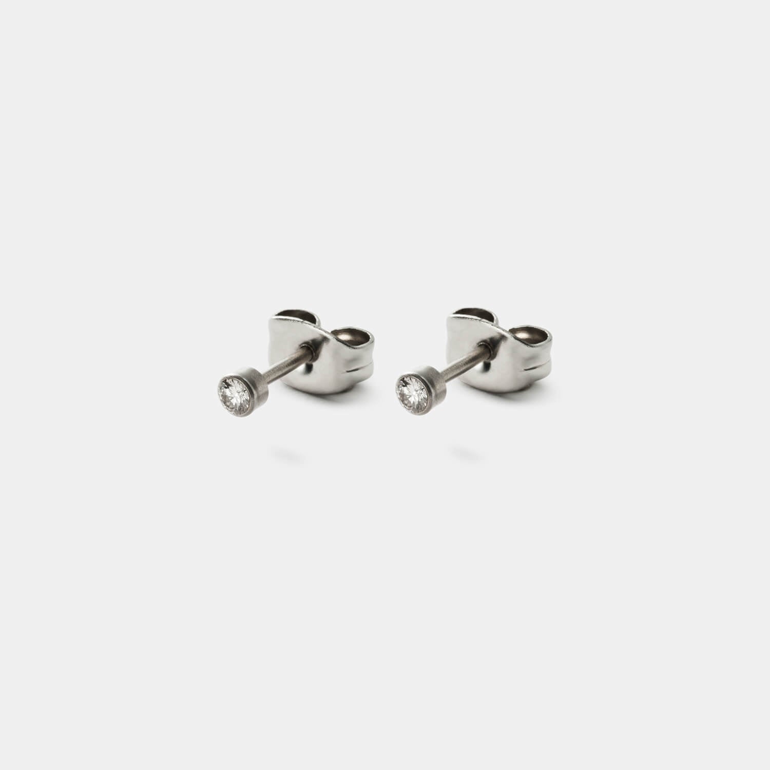Gesamtansicht eines klassischen Ohrstecker-Paars aus antiallergenem Edelstahl mit zwei gefassten Diamanten (gesamt 0,08 ct TWsi) von MONOMANIA.