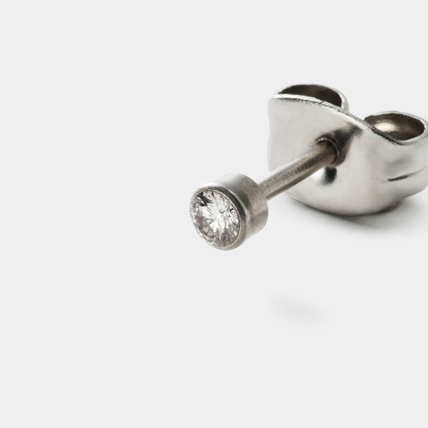 Gesamtansicht eines klassischen Ohrstecker-Paars aus antiallergenem Edelstahl mit zwei gefassten Diamanten (gesamt 0,08 ct TWsi) von MONOMANIA.