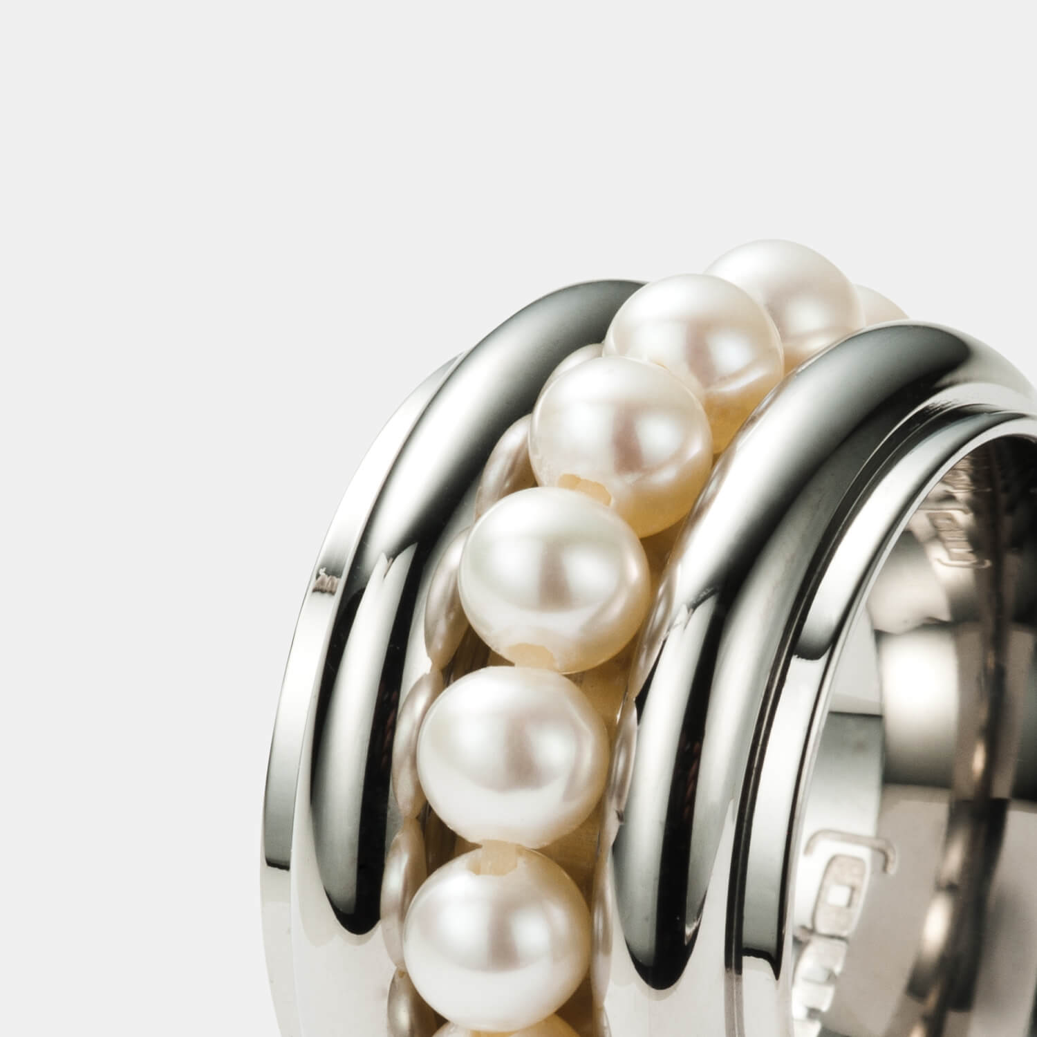 Gesamtansicht eines universell einsetzbaren Rings aus poliertem, antiallergenen Edelstahl mit weißem Süßwasserperlenkranz von MONOMANIA.