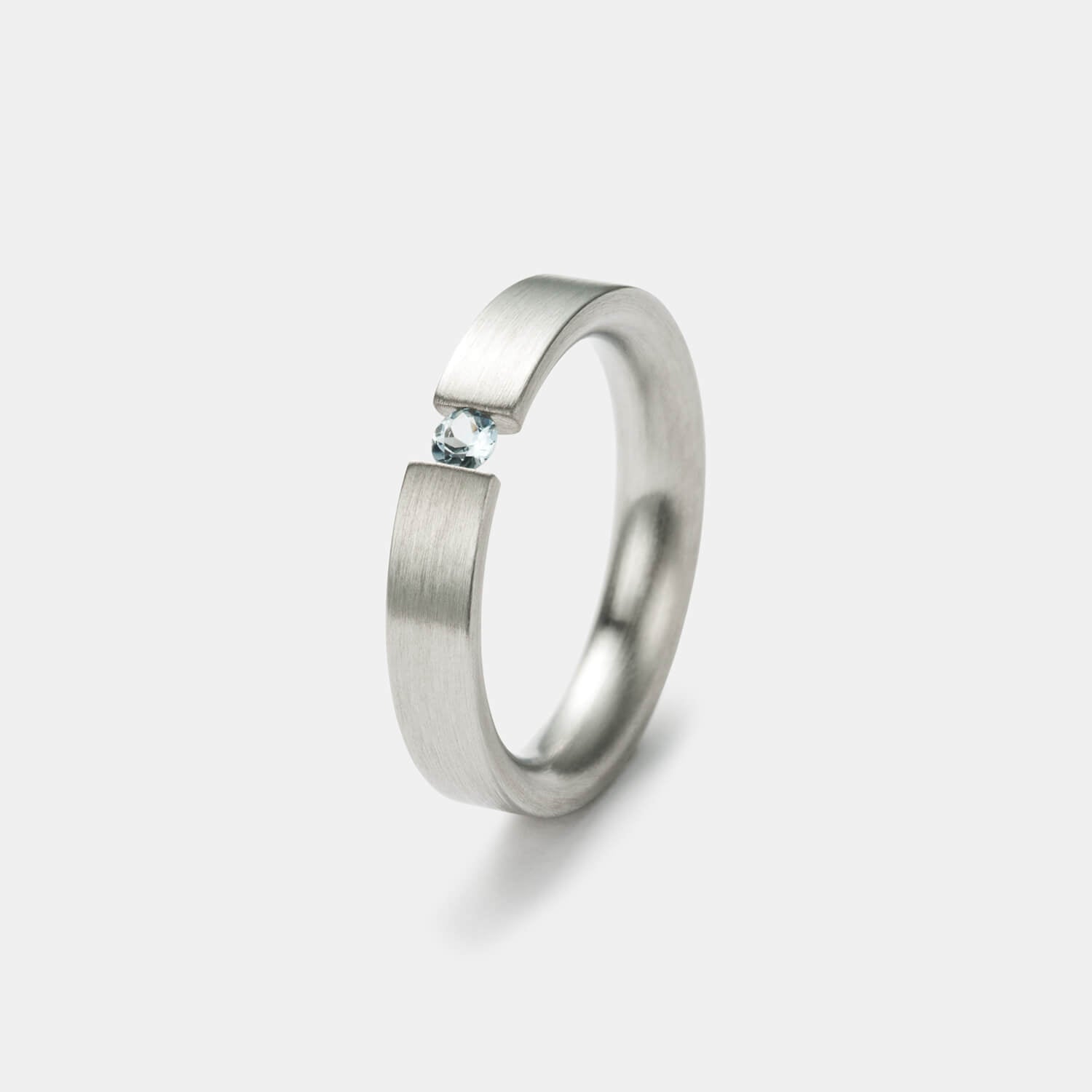 Wunderschöner, gerader Spannring aus gebürstetem, antiallergenen Edelstahl mit einem eingespannten Aquamarin von MONOMANIA in Gesamtansicht.