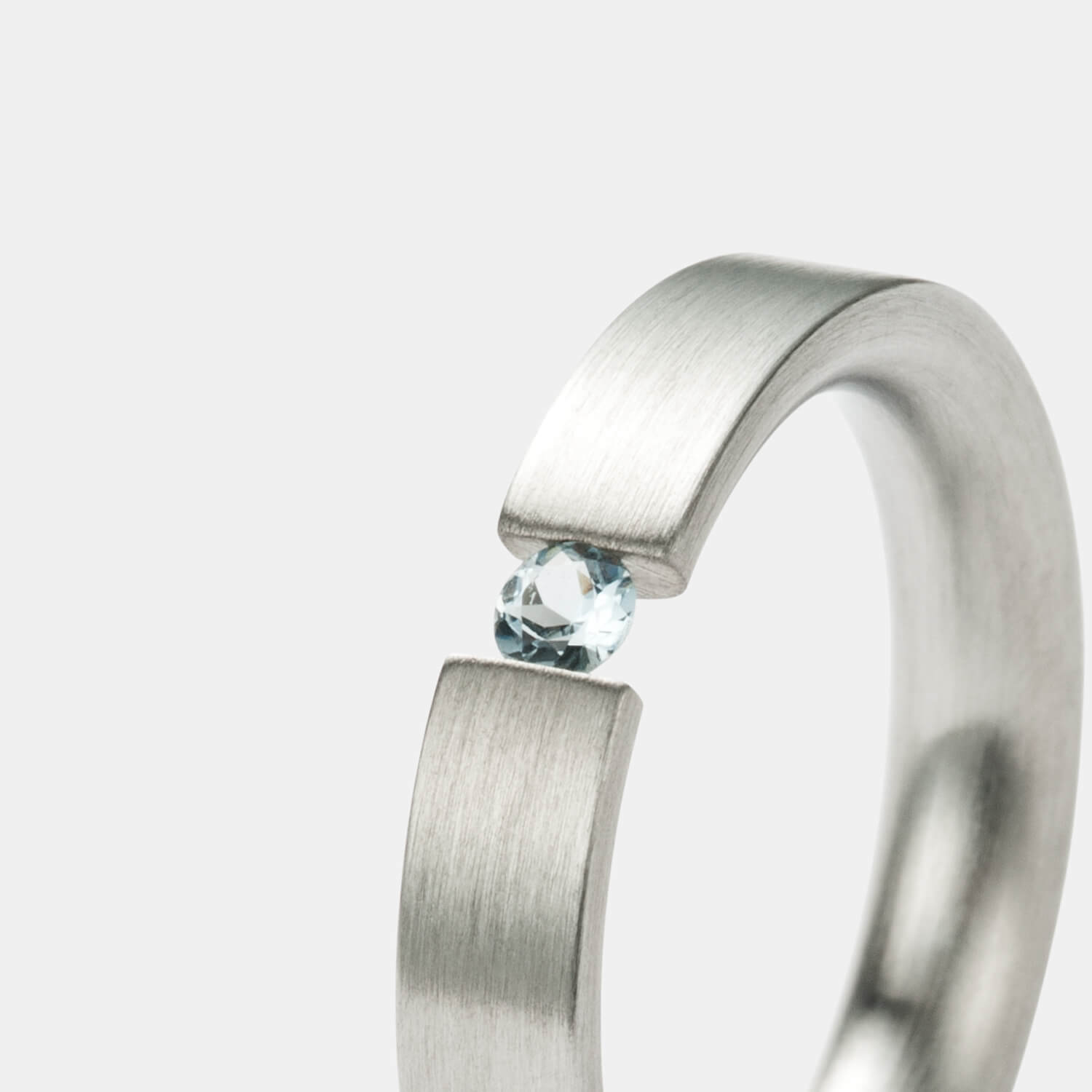 Wunderschöner, gerader Spannring aus gebürstetem, antiallergenen Edelstahl mit einem eingespannten Aquamarin von MONOMANIA in Gesamtansicht.