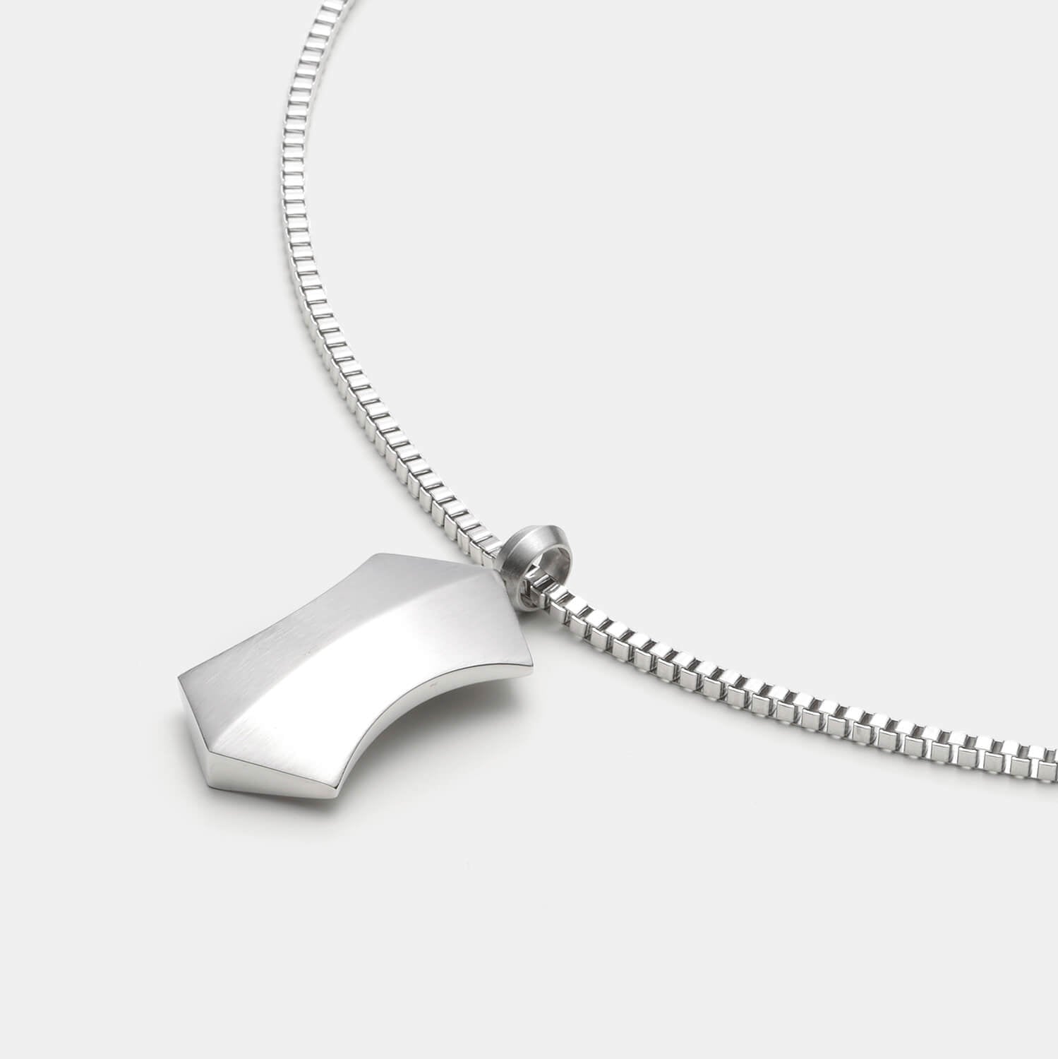 Detailansicht eines silberfarbenen, großen Kettenanhängers in Trapezform aus antiallergenem Edelstahl an einer Veneziakette.