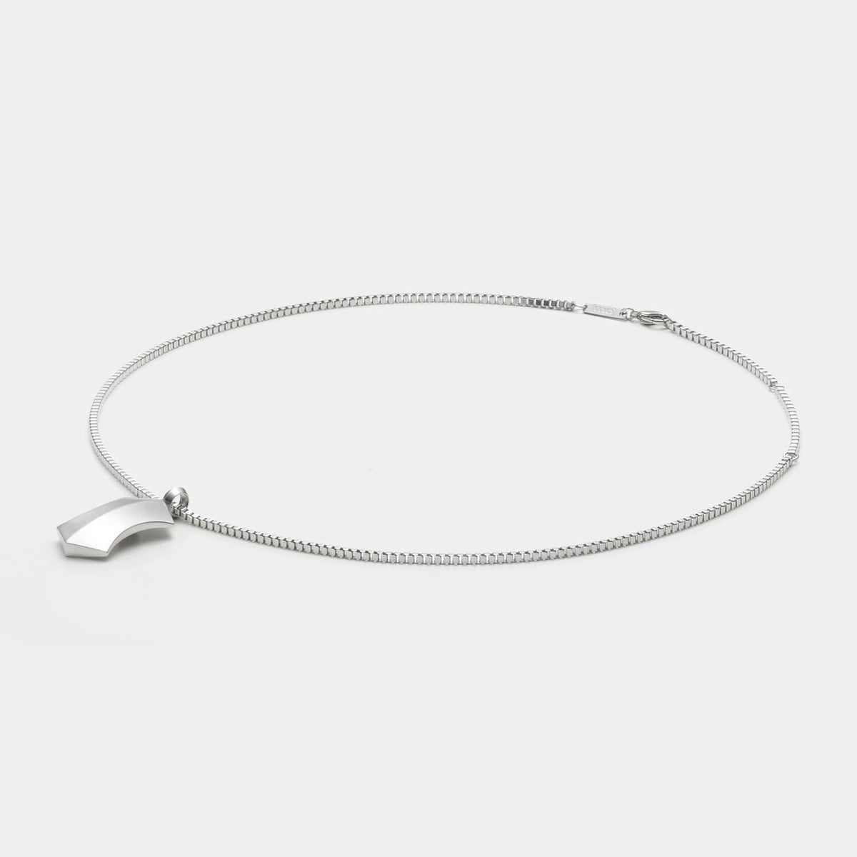 Detailansicht eines silberfarbenen, großen Kettenanhängers in Trapezform aus antiallergenem Edelstahl an einer Veneziakette.