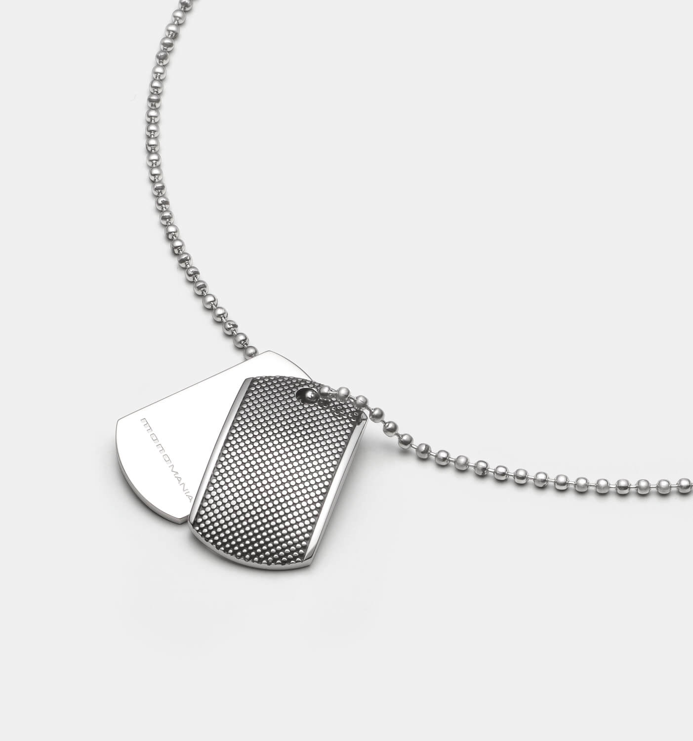 Detailansicht eines silberfarbenen Dog Tag Anhänger-Sets aus antiallergenem Edelstahl mit Punkterelief an einer Kugelkette.
