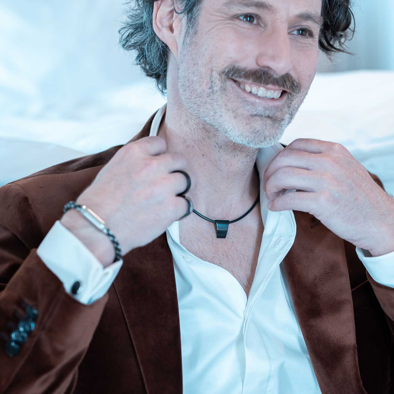 Detailansicht eines schlichten, schwarzen Anhängers aus antiallergenem Edelstahl an einem schwarzen Kautschukband von MONOMANIA.