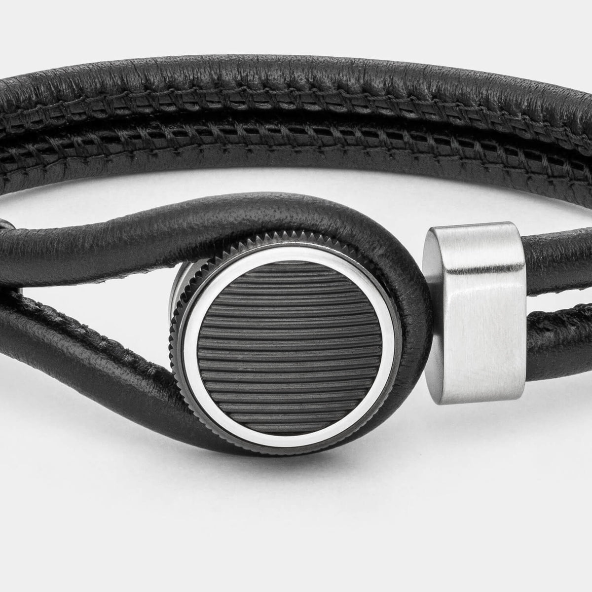 Gesamtansicht eines schwarzen Lederarmbandes mit edlem Designverschluss aus antiallergenem Edelstahl in Schwarz und Silber von MONOMANIA.