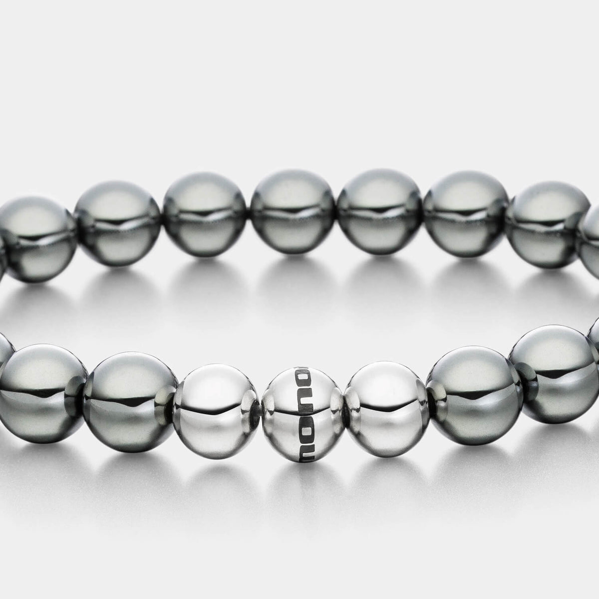 Gesamtansicht eines Perlenarmbandes aus echten grauen Hämatit-Perlen mit drei antiallergenen Edelstahlperlen von MONOMANIA.