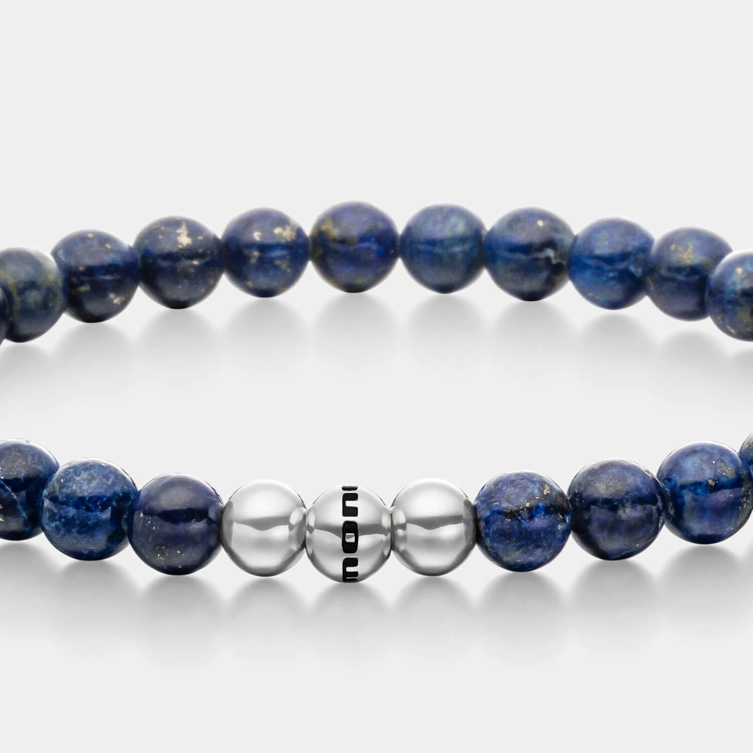 Gesamtansicht eines blauen Perlenarmbandes aus echten Lapislazuliperlen mit drei antiallergenen Edelstahlperlen.