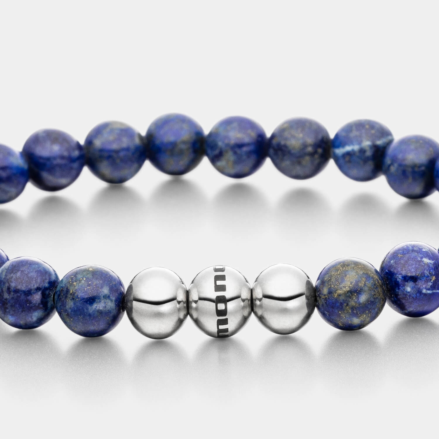 Gesamtansicht eines blauen Perlenarmbandes aus echten Lapislazuli-Perlen mit drei antiallergenen Edelstahlperlen.