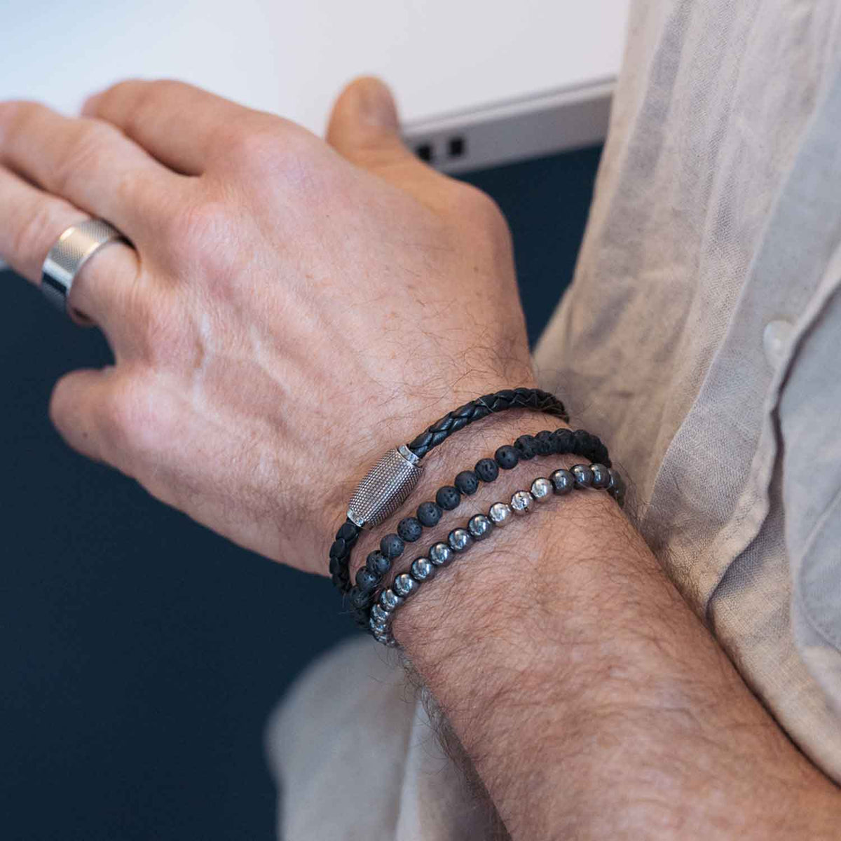 Gesamtansicht eines schwarzen Perlenarmbandes aus echten Lavaperlen mit drei antiallergenen Edelstahlperlen.