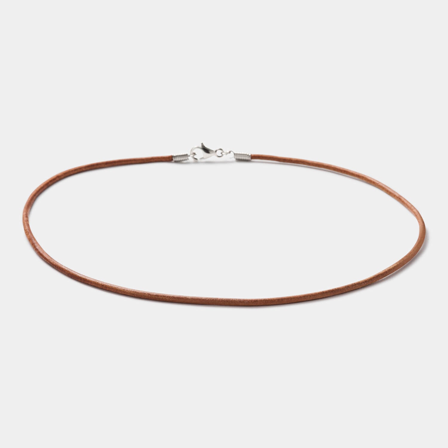 Detailansicht eines runden, braunen Lederbandes mit Karabinerverschluss aus antiallergenem Edelstahl von MONOMANIA.