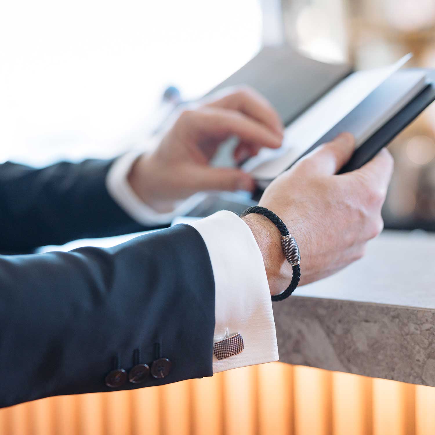 Ansicht von zwei Edelstahl-Manschettenknöpfen mit schwarzem Punkterelief von MONOMANIA.