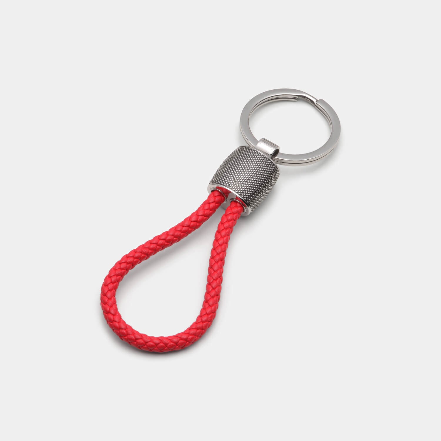 Gesamtansicht eines Schlüsselanhängers aus antiallergenem Edelstahl mit Punkterelief und roter Lederschlaufe von MONOMANIA.