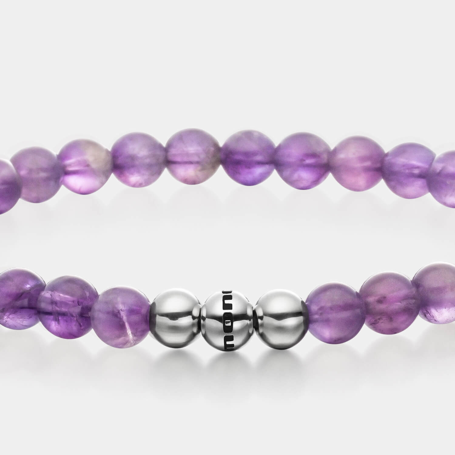 Gesamtansicht eines violetten Perlenarmbandes aus echten Amethystperlen mit drei antiallergenen Edelstahlperlen.