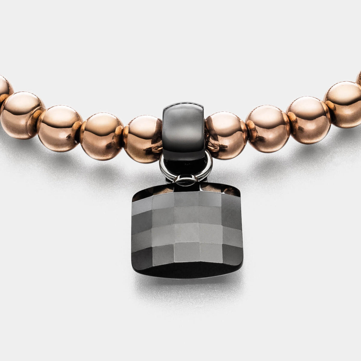 Gesamtansicht eines Perlenarmband-Sets: roségoldfarbenes Perlenarmband mit schwarzem Keramik-Anhänger von MONOMANIA.