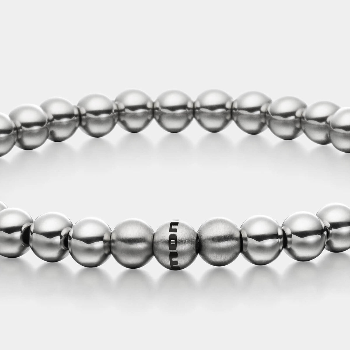 Gesamtansicht eines silber-farbenen Perlenarmbandes mit polierten und drei gebürsteten, antiallergenen Edelstahlperlen.