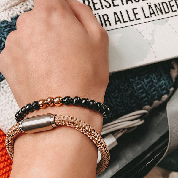 Gesamtansicht eines  Perlenarmbandes aus schwarzen und roségoldfarbenen Edelstahl-Perlen.