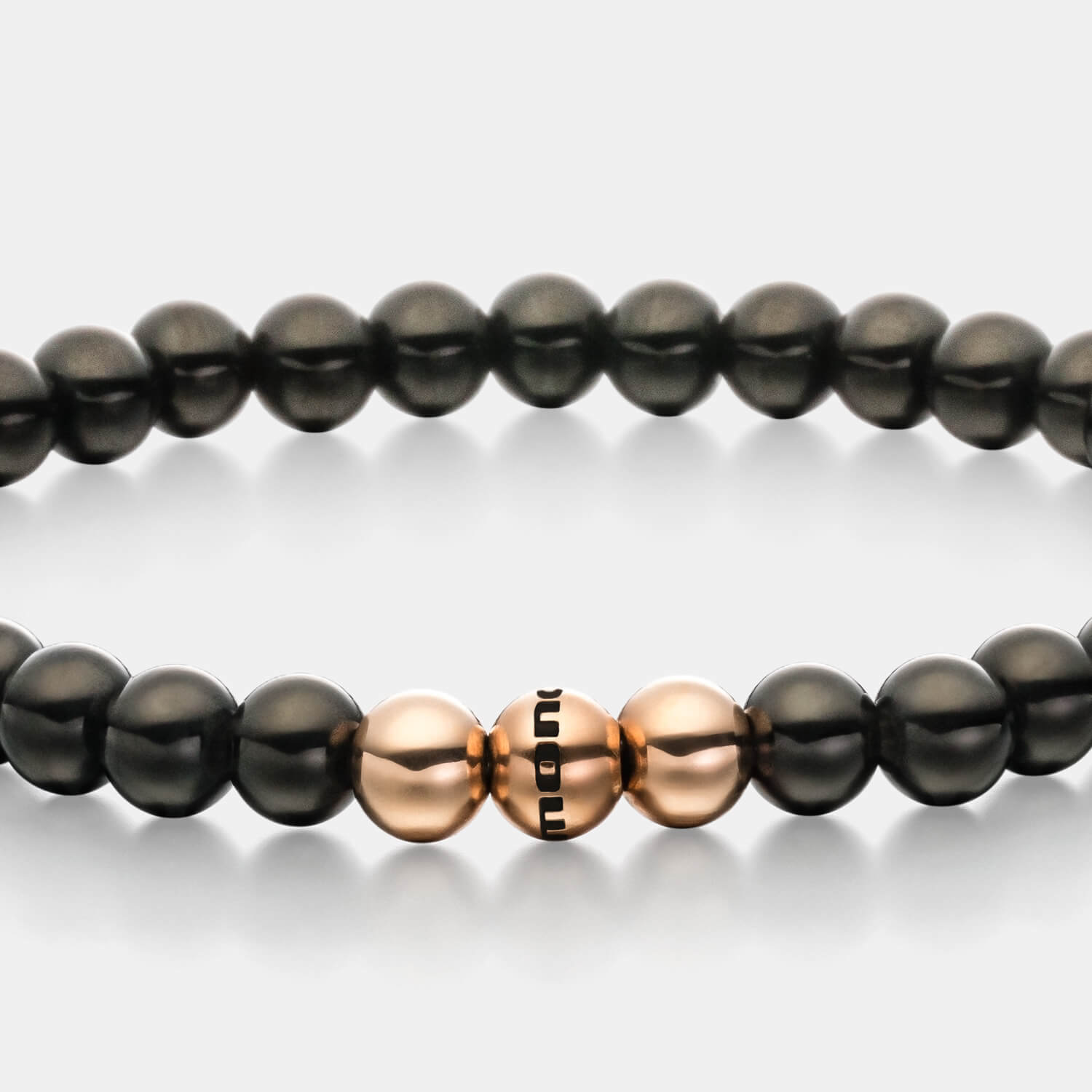 Gesamtansicht eines  Perlenarmbandes aus schwarzen und roségoldfarbenen Edelstahl-Perlen.