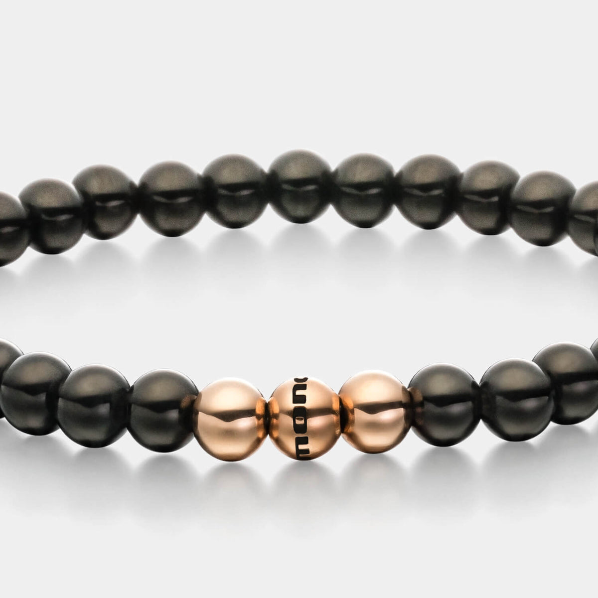 Gesamtansicht eines  Perlenarmbandes aus schwarzen und roségoldfarbenen Edelstahl-Perlen.