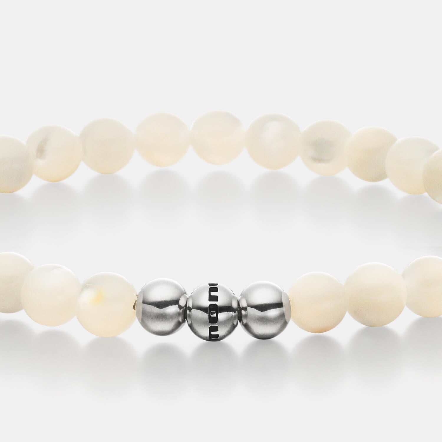 Gesamtansicht eines  Perlenarmbandes aus weißen Perlmutt-Perlen.