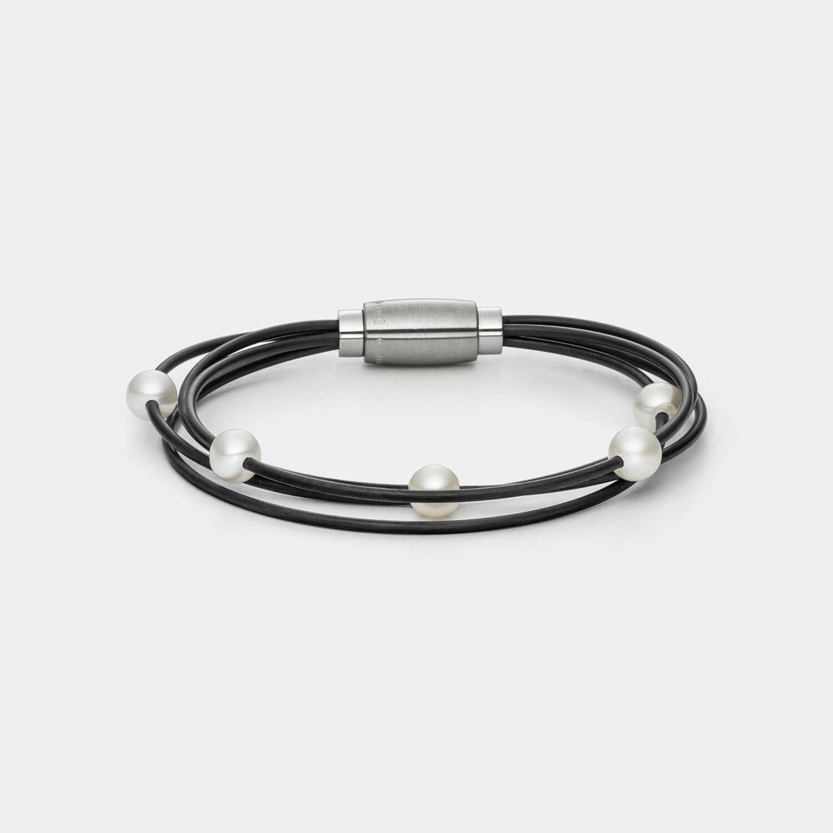 Gesamtansicht des modernen Armbandes mit echten, weißen Süßwasserperlen auf einem vierreihigen Kautschukband von MONOMANIA.