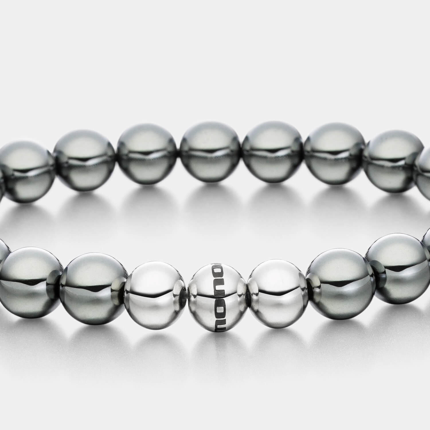 Gesamtansicht eines  Perlenarmbandes aus echten grauen Hämatit-Perlen mit drei antiallergenen Edelstahlperlen von MONOMANIA.
